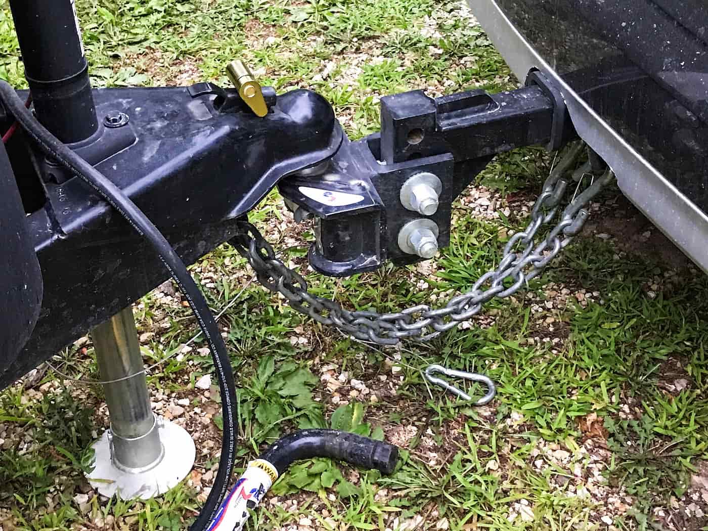 A ball mount with safety chains attached, fitted to a vehicle receiver and ready to hitch