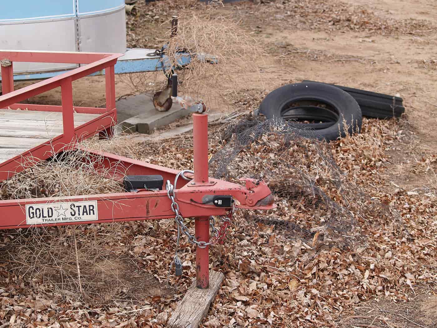 A trailer tongue and jack on an older utility trailer