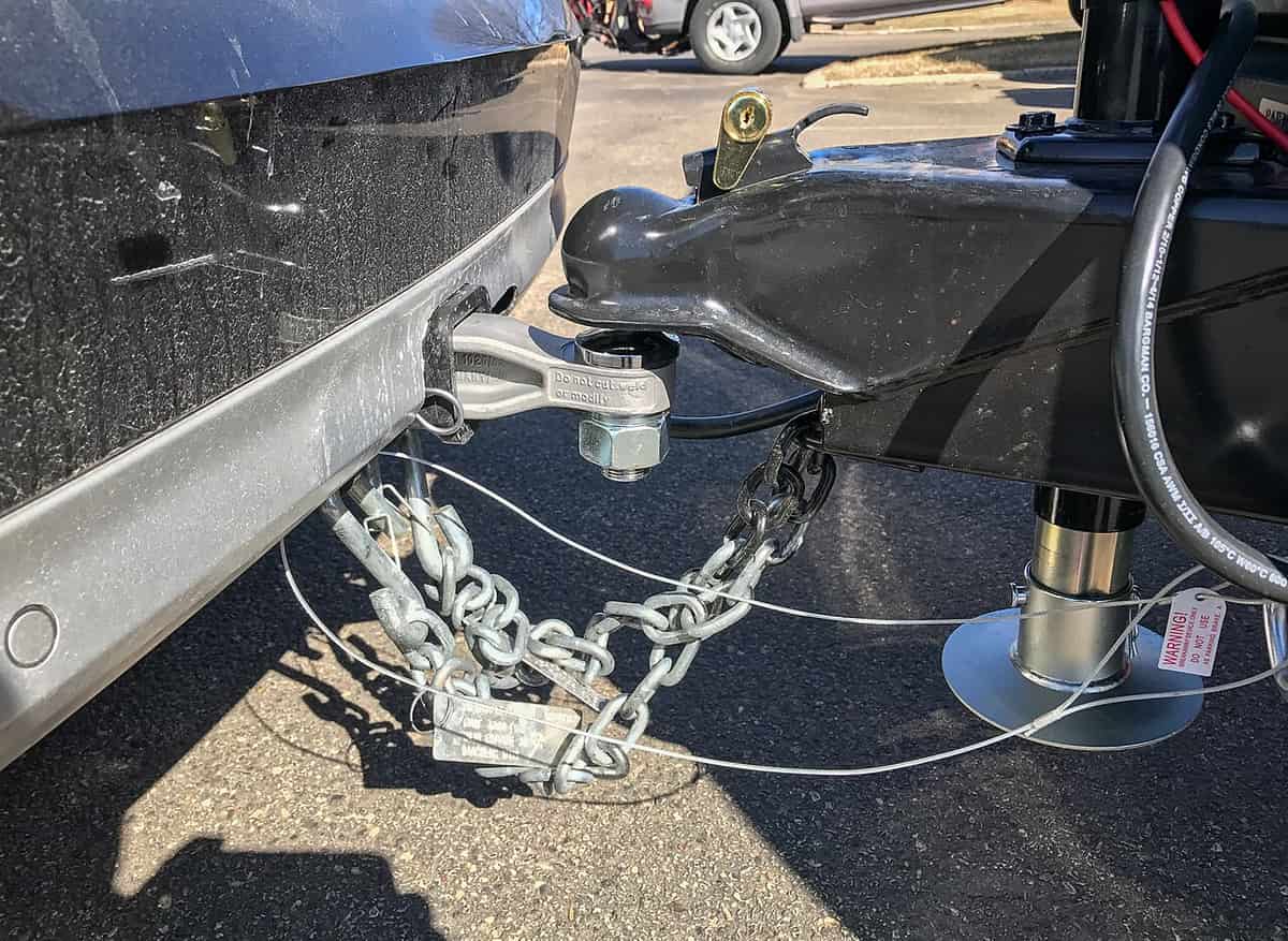 A trailer coupler on a hitch ball with safety chains attached and crossed