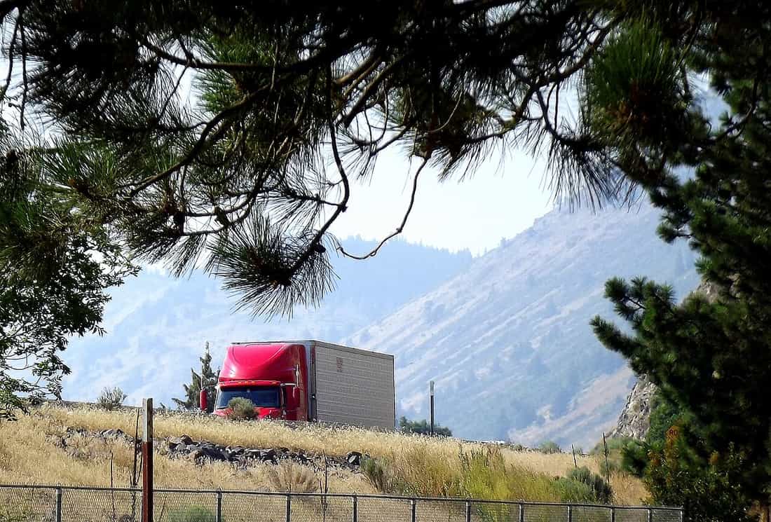 A large truck passing a vehicle on a multi-lane highway