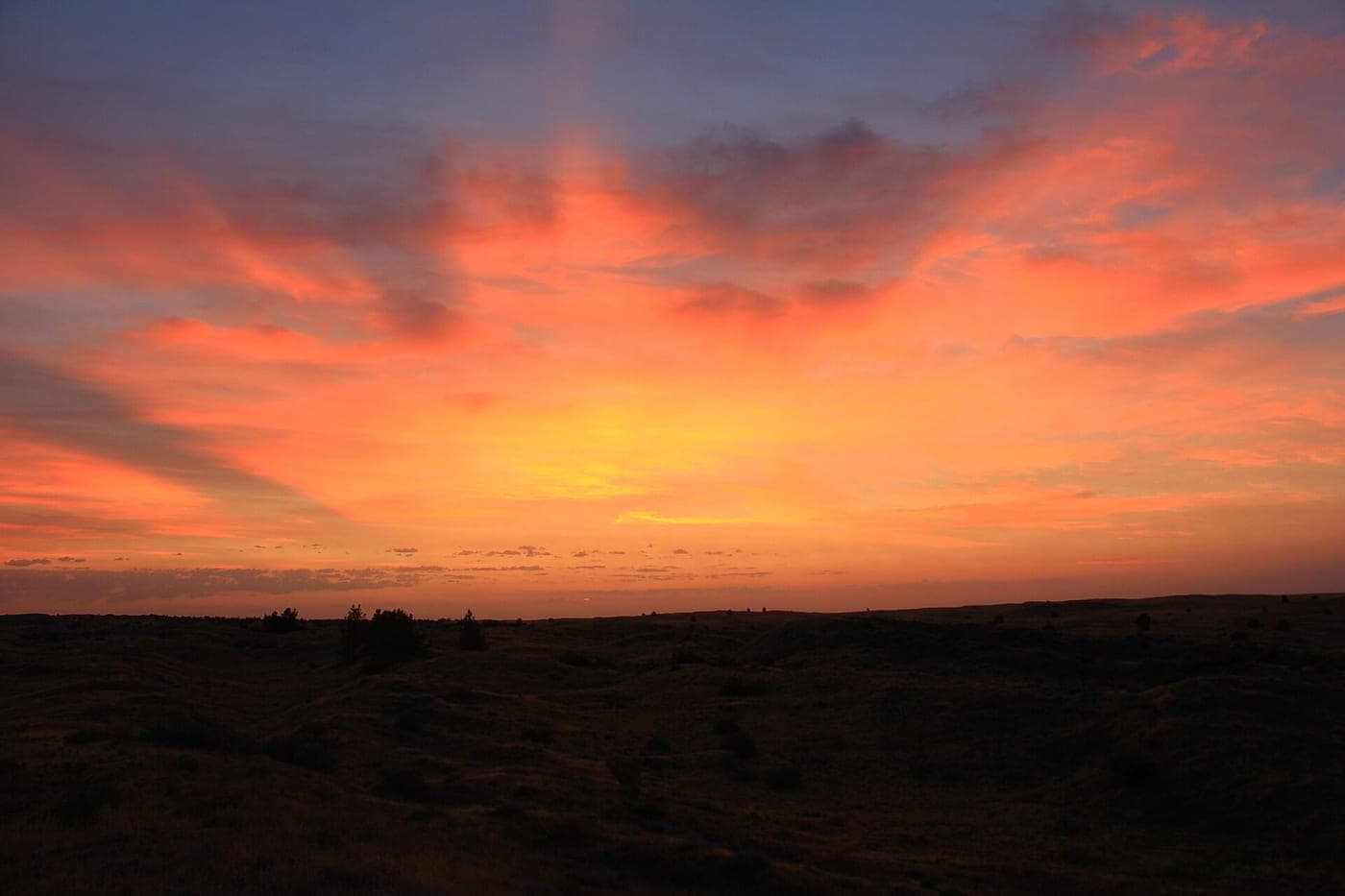 A highway at dusk under a broad sky, the kind of open road where crosswinds build