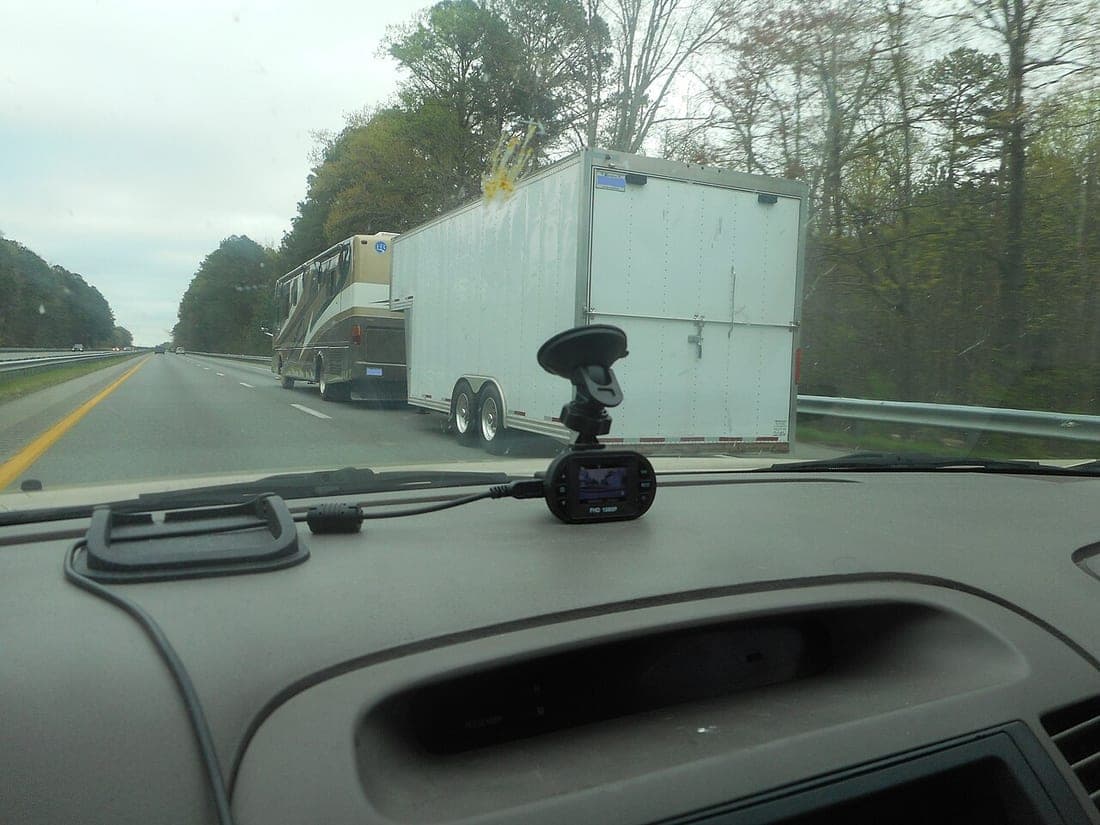 A pickup truck and travel trailer on an open highway at speed